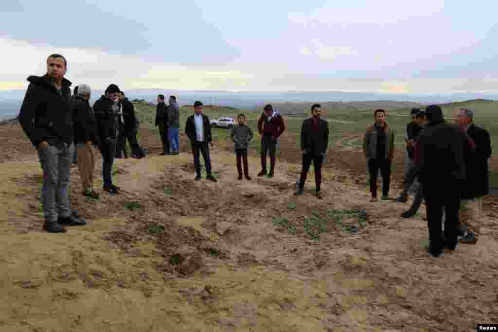 Residents look at a crater caused by a missile launched by Iran on U.S.-led coalition forces on the outskirts of Duhok, Iraq.