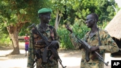 Deux soldats discutent devant leur base, dans la ville de Nyal, contrôlée par les rebelles, dans l'état d'Unity, au Soudan du Sud, le 15 août 2018.