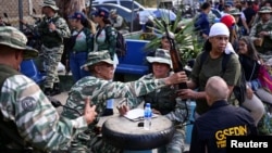 Miembros de la Milicia Nacional Bolivariana entregan rifles de asalto a civiles en las cercanías del Palacio de Miraflores, en Caracas, el 7 de enero de 2025.