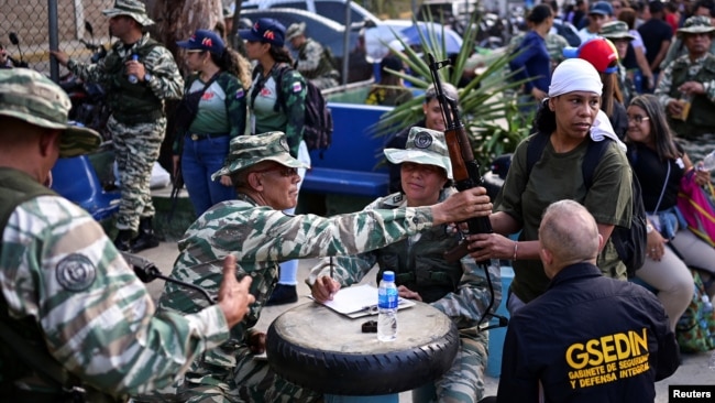 Miembros de la Milicia Nacional Bolivariana entregan rifles de asalto a civiles en las cercanías del Palacio de Miraflores, en Caracas, el 7 de enero de 2025.