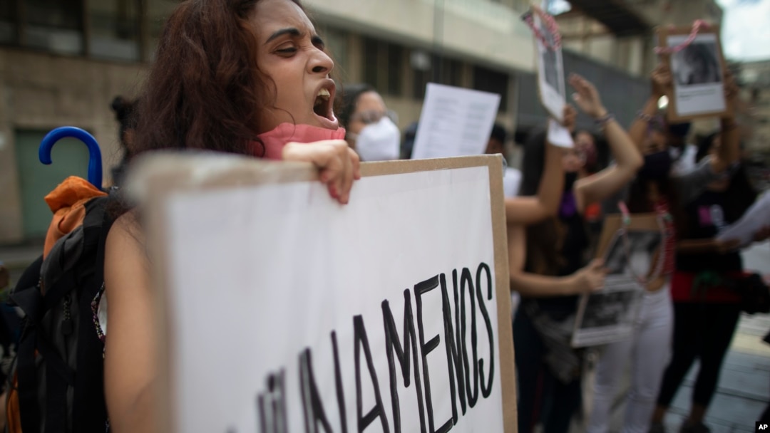Venezuela'da kadınlara yönelik şiddet eylemlerinin protesto edildiği bir yürüyüşte bir kadın elinde pankartla gösteriye katılıyor. 
