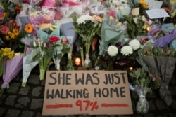 FILE - A sign is seen as people gather at a memorial site in Clapham Common Bandstand, following the kidnap and murder of Sarah Everard, in London, Britain, March 13, 2021.