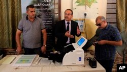 Employees of the Independent High Electoral Commission explain the election process, during a press conference in Baghdad, Iraq, April 30, 2018. 