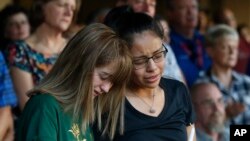 FILE - High School students Celeste Lujan, left, and Yasmin Natera mourn their friend Leila Hernandez, one of the victims of the Saturday shooting in Odessa, at a memorial service in Odessa, Texas, Sept. 1, 2019.