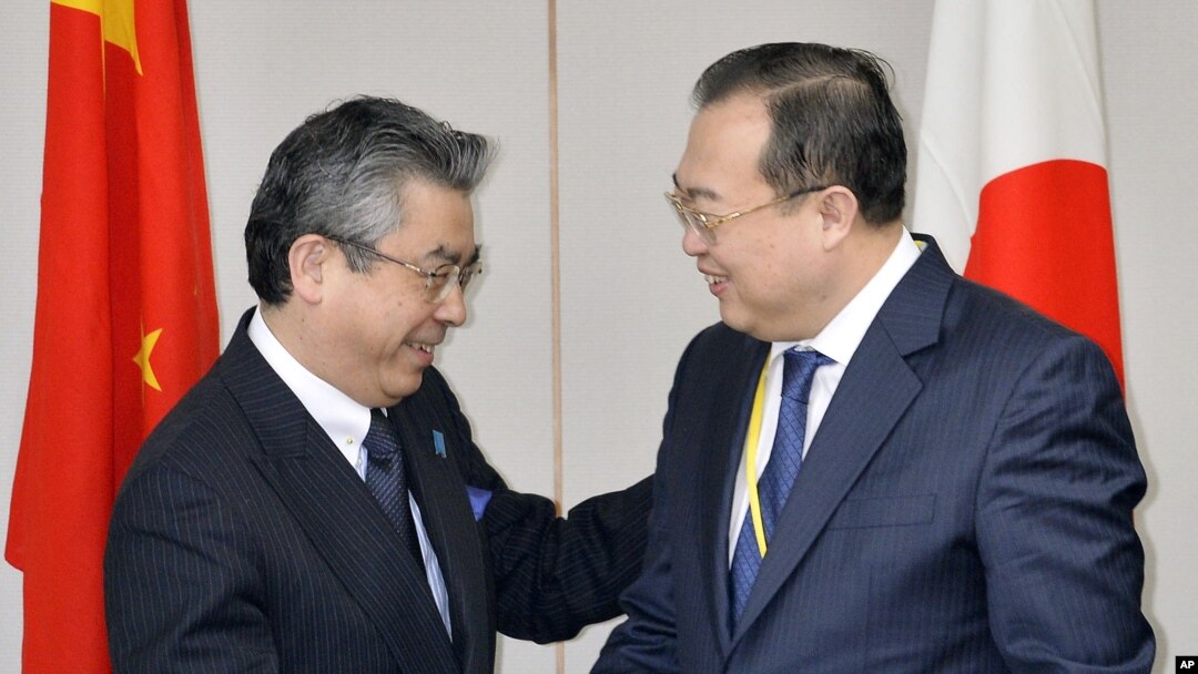 Wakil Menteri Luar Negeri Jepang Shinsuke Sugiyama (kiri) bersama Asisten Menteri Luar Negeri China Liu Jianchao dalam pertemuan di Tokyo (19/3). (AP/Kyodo News)