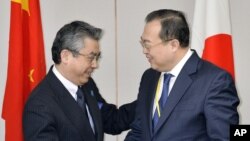 Wakil Menteri Luar Negeri Jepang Shinsuke Sugiyama (kiri) bersama Asisten Menteri Luar Negeri China Liu Jianchao dalam pertemuan di Tokyo (19/3). (AP/Kyodo News)