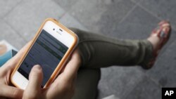 In Seoul, woman surfs the Web on an Apple iPhone. The 4S model is about to go on sale in China and other countries, June 2011 (file photo).