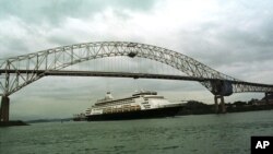 Un barco crucero de Holland American Cruise pasa bajo el Puente de las Américas, tras navegar el canal interoceánico. Un barco similar está ahora a la espera de ser reabastecido mientras varios pasajeros muestran posibles síntomas de coronavirus.