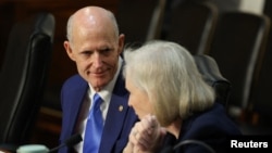 资料照片：美国参议院老龄问题特别委员会在华盛顿特区举行一场听证会期间，佛罗里达州的共和党籍参议员里克·斯科特与纽约州的民主党籍参议员柯尔斯滕·吉利布兰德进行交谈。(2025年10月22日)