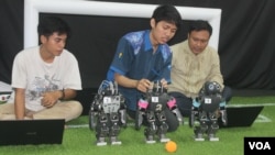 Mahasiswa ITS Surabaya mendemonstrasikan robot pemain sepak bola buatan tim robot ITS. (Foto: VOA/Petrus Riski).