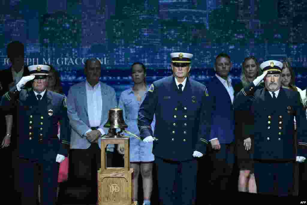 Firefighters stand next to a bell for a tribute to mark the 25th anniversary of the 9/11 attacks during the second day of the Republican National Committee midterm convention at the American Airlines Center in Dallas, Texas on September 10, 2026.