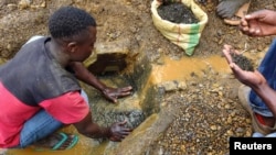 FILE - An artisanal miner washes tin ore before it is bagged up and weighed, ready to be transported to the nearest major town for export in the Kalimbi tin mine near the small town of Nyabibwe, DRC.