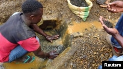 Un mineur nettoie de l'étain avant d'être pesé, et ensuite préparé à être transporté rprès d'une grande ville où le minerai sera exporté à Kalimbi depuis la mine d'étain de Nyabibwe, RDC.