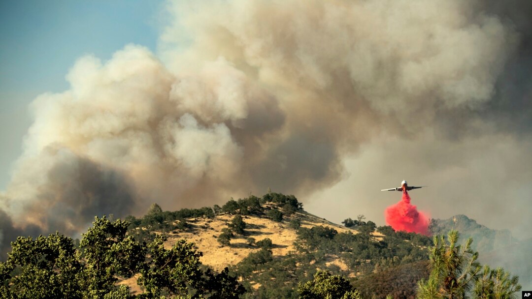 Un avión tanque arroja retardante sobre un incendio forestal en la comunidad de Spring Lakes el domingo, 24 de junio de 2018, cerca de Clearlake Oaks, California.