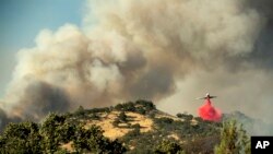 Un avión tanque arroja retardante sobre un incendio forestal en la comunidad de Spring Lakes el domingo, 24 de junio de 2018, cerca de Clearlake Oaks, California.