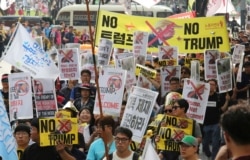 Protesters march after a rally to oppose a planned visit by the U.S. President Donald Trump in Seoul, South Korea, Saturday, June 29, 2019.