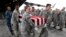 In this Sept. 13, 2018 photo, military personnel carry flag-draped transfer cases containing remains of unidentified service members to waiting trucks, at Offutt AFB in Bellevue, Neb. The remains were gathered through various DPAA missions in Europe.