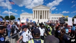 Agentes de policía de la Corte Suprema de EEUU y agentes de policía del Capitolio de EEUU colocan barreras entre manifestantes contra el aborto y manifestantes a favor del derecho al aborto, el 24 de junio de 2024, en Washington.
