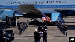 The flag-draped casket of former President George H.W. Bush is carried by a joint services military honor guard to Special Air Mission 41 at Ellington Field during a departure ceremony Monday, Dec. 3, 2018, in Houston, TX. 