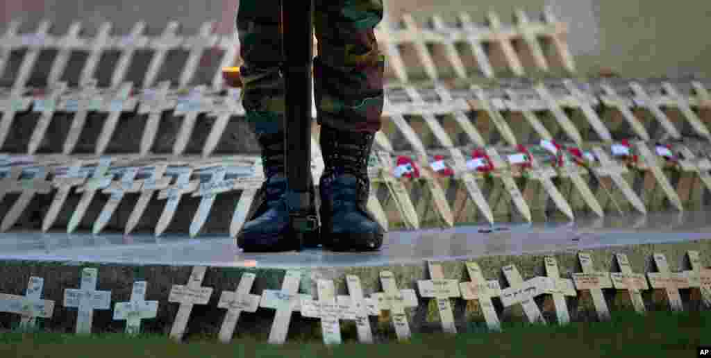 A soldier stands on a memorial filled with wooden crosses and red poppies during an Anzac Day service at Polygon Wood in Zonnebeke, Belgium. Anzac Day is commemorated by New Zealand and Australia to remember the service of those who fought in all wars.