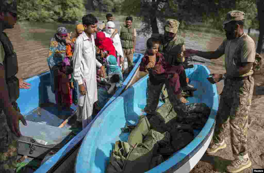 سربازان به افراد سیل&zwnj;زده کمک می&zwnj;کنند تا از قایق پیاده شوند &ndash; مولتان، ۲۲ شهریور ۱۳۹۳