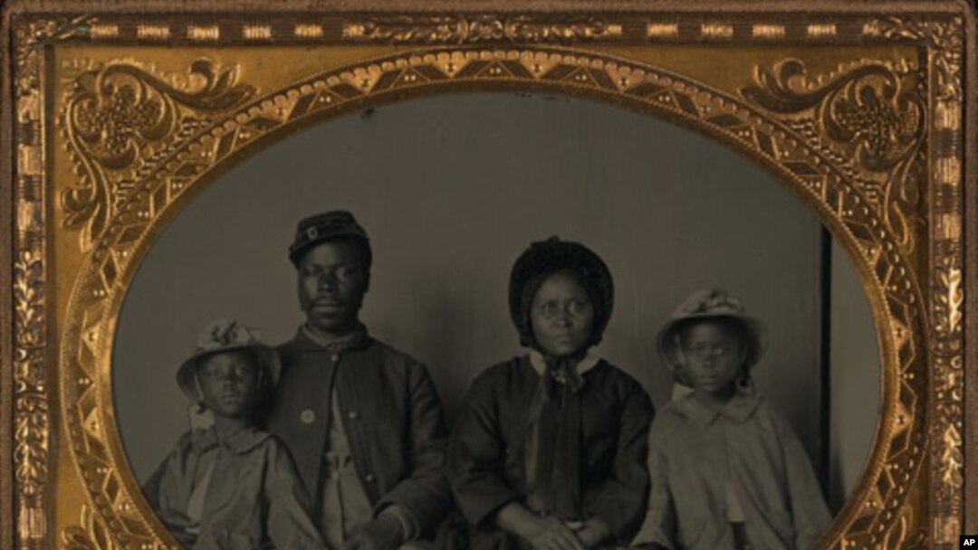 Unidentified African American soldier in Union uniform with wife and two daughters between 1863 and 1865.