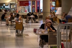 FILE - People eat in the food court at the Eaton Centre shopping center after indoor dining restaurants, gyms and cinemas re-open under Phase 3 rules from coronavirus disease restrictions in Toronto, Ontario, Canada, July 31, 2020.