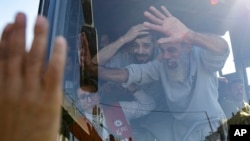 Prisioneros palestinos liberados saludan desde un autobús cuando llegan a la Franja de Gaza después de ser liberados de una prisión israelí tras un acuerdo de alto el fuego entre Hamas e Israel en Khan Younis, el sábado 1 de febrero de 2025.