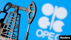 FILE - A 3D printed oil pump jack is seen in front of displayed OPEC logo in this illustration picture, April 14, 2020. 