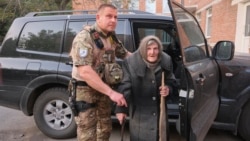 En esta fotografía proporcionada por la Policía Nacional Ucraniana de la región de Donetsk, Lidia Lomikovska, de 98 años, recibe ayuda de un oficial de policía ucraniano después de escapar del territorio ocupado por Rusia en la región de Donetsk, Ucrania, el 26 de abril de 2024.