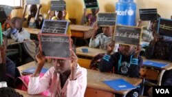 Second-graders in Alieu Samb primary school hold up chalk boards with French conjugations. Dakar, Senegal, Dec. 7 2017. (Photo: Sofia Christensen for VOA) 