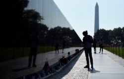 FILE - With the Washington Monument in the background, people visit the Vietnam Memorial in Washington on May 27, 2016, on the start of the Memorial Day weekend.