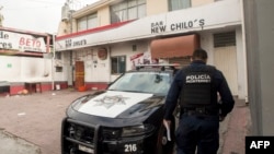 A police officer guards a bar where people were shot dead at dawn in an attack, in Monterrey, Nuevo Leon, Mexico, July 8, 2018.