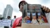 FILE - A protester displays a copy of the Indonesian news weekly, Tempo, during a demonstration against the magazine in Jakarta, Feb. 6, 2008. 