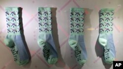 La alfombra que está siendo reemplazada en el aeropuerto de Portland, Oregon también ha generado un aumento en el mercadeo de productos como estas medias con el diseño de la alfombra que se están vendiendo en la terminal aérea.