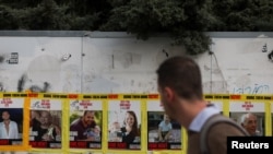 Un hombre pasa junto a fotografías de Yarden Bibas, Shiri Bibas y Kfir Bibas, quienes fueron secuestrados durante el mortal ataque del 7 de octubre de 2023 contra Israel, en Jerusalén, el 19 de febrero de 2025.