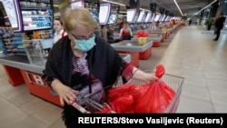 Montenegro, Podgorica, A woman wears a mask as she packs her groceries
