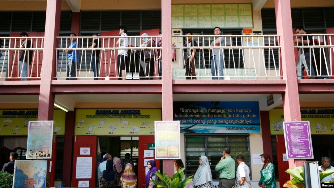 Para calon pemilih antri untuk memberikan suaranya dalam Pemilu Nasional Malaysia, di salah satu TPS di Permatang Pauh, 350 kilometer sebelah utara Kuala Lumpur (5/5).