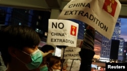 People hold placards during a protest against a proposed extradition bill, near the Legislative Council building in Hong Kong, June 13, 2019. 