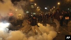 An environment supporter kicks a tear gas canister in Santiago, May 13, 2011, during a rally against hydro-power dam project which will be built at the southern Chilean Patagonia