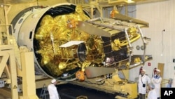 In this Nov.2, 2011 photo distributed by Russian Roscosmos space agency on Wednesday, Nov. 9, 2011, Russian space engineers work to prepare the unmanned Phobos-Grunt probe in the Baikonur Cosmodrome, Kazakhstan.