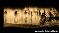 People cool down in a fountain beside Manzanares river in Madrid, Spain, June 30, 2015. 