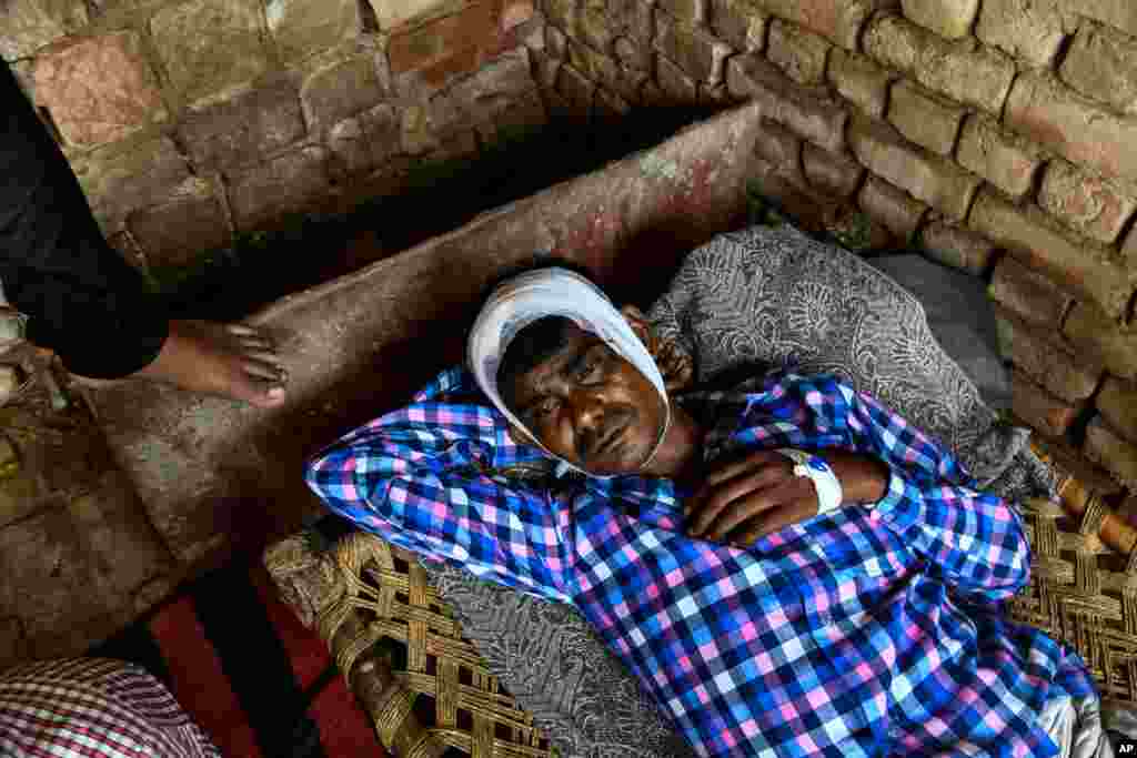 Dharamveer Singh, 36, looks on as he rests in his home that was damaged by heavy storm winds in Kheragarh on the outskirts of Agra.