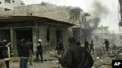 FILE - This photo provided by the Syrian anti-government activist group EMC shows members of the Syrian civil defense known as the White Helmets, gathering at a street which was attacked by Russian airstrikes, in Maarat al-Nuaman town, southern Idlib province, Syria.