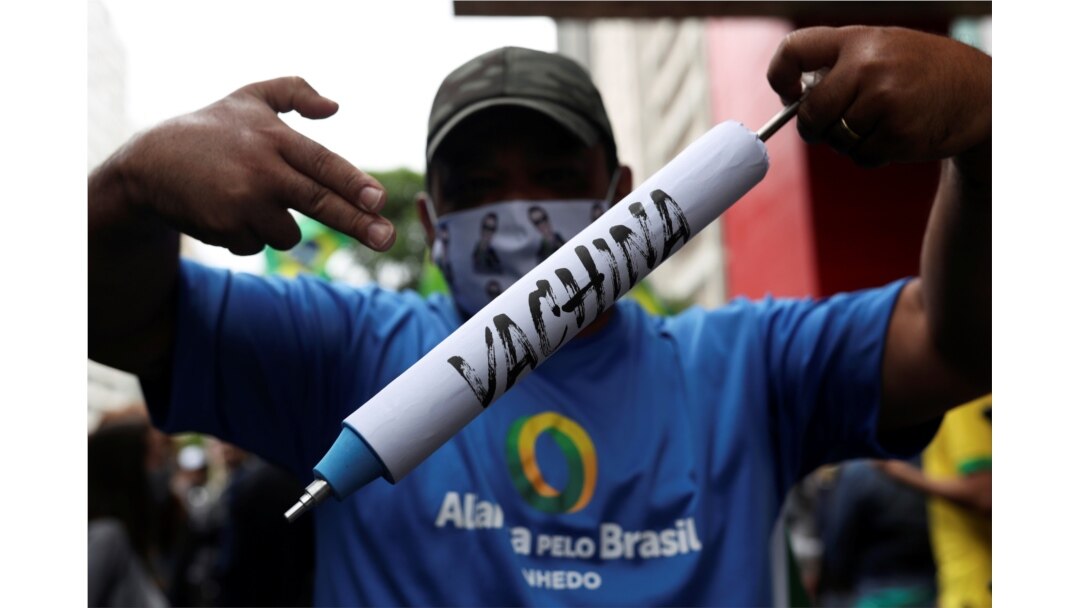 FILE - A man holds a mock syringe as demonstrators protest against Sao Paulo state governor Joao Doria and China's Sinovac COVID-19 vaccine, in Sao Paulo, Brazil, Nov. 1, 2020.