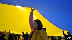 Ucranianos que viven en Georgia y otros manifestantes marchan con una bandera ucraniana gigante en protesta por la agresión militar de Rusia contra Ucrania en el segundo aniversario de la guerra en Tbilisi, Georgia, el 24 de febrero de 2024. [Foto: Archivo/AP]