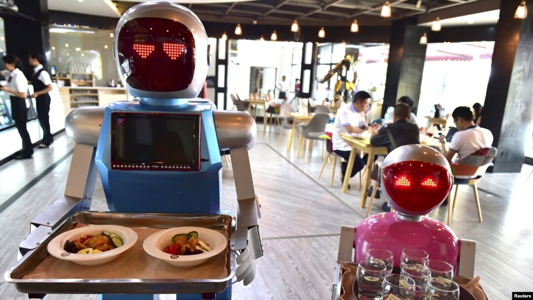 Sepasang robot membawa nampan makanan di sebuah restoran sebagai ilustrasi. Restoran White Fox di Mosul, Irak, menjadi sorotan, bukan karena suasana yang nyaman atau makanan dan minuman yang lezat, melainkan pelayannya. (Foto: Reuters)