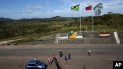 Archivo. En esta foto del 10 de marzo de 2018 se ve gente en la frontera entre Venezuela y Brasil cerca de la ciudad brasileña de Pacaraima, en el Estado Roraima.