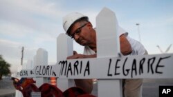 FILE - Greg Zanis prepares crosses to place at a memorial for victims of a mass shooting in El Paso, Texas, Aug 5, 2019. The Illinois man who made and delivered more than 27,000 crosses to sites around the U.S., is retiring.