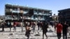 Palestinians walk in the courtyard of a school after an Israeli airstrike hit the site, in Nuseirat in the central Gaza Strip, Sept. 11, 2024